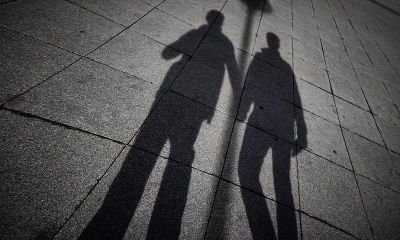 A shadow of two men holding hands (Unspalsh)