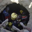 A young girl passes up a jerrycan filled with murky water trickling into a waterhole from underground rocks near Lokitaung in northern Kenya's Turkana county