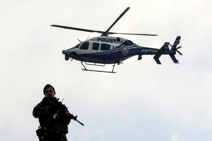 A police helicopter flies overhead as defendants are escorted towards the courthouse in Mugla, western Turkey, on February 20, 2017