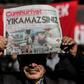 A protester holds a copy of the latest edition of the Turkish daily newspaper Cumhuriyet during a demonstration outside the newspaper's headquarters in Istanbul on November 2,2016