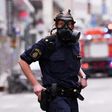Police officers wearing gas masks on duty at the scene of a truck attack in central Stockholm on April 7, 2017