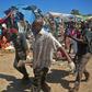 Soldiers assisted by some residents carry the body of a victim from the scene of a suicide car bomb attack at a market in Somalia's capital, Mogadishu on November 26, 2016