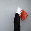 A woman holds the flag of Bahrain, a Shiite-majority Gulf kingdom