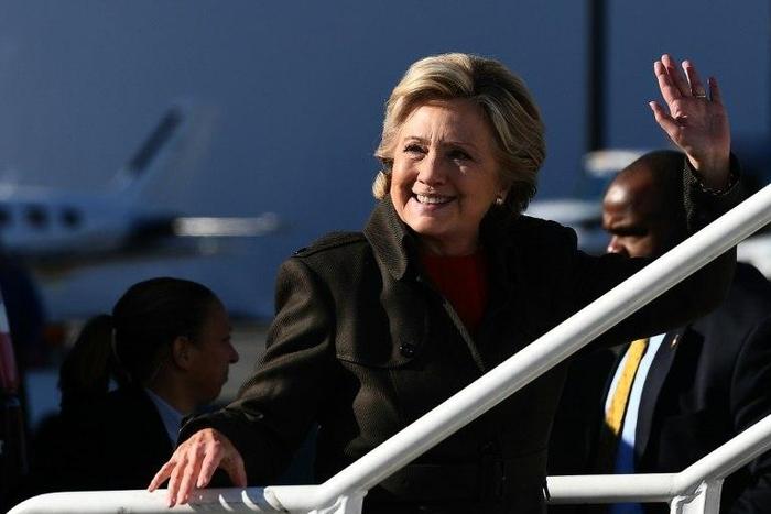 US Democratic presidential nominee Hillary Clinton waves as she boards her campaign plane at the Westchester County Airport in White Plains, New York, on October 31, 2016