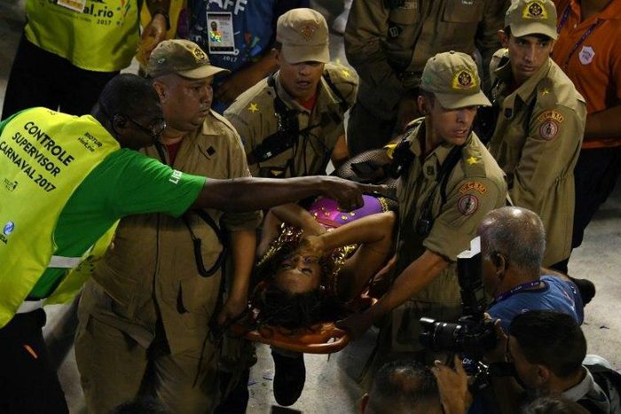 Firefighters assist a reveller of the Unidos da Tijuca samba school at the Sambadrome in Rio de Janeiro early on February 28, 2017, after the third floor of an allegorical car collapsed during the second night of Rio Carnival