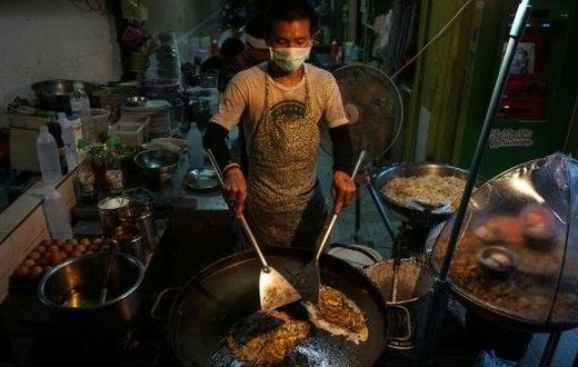 A man prepares food at a street stall in the Phrakanong district of Bangkok