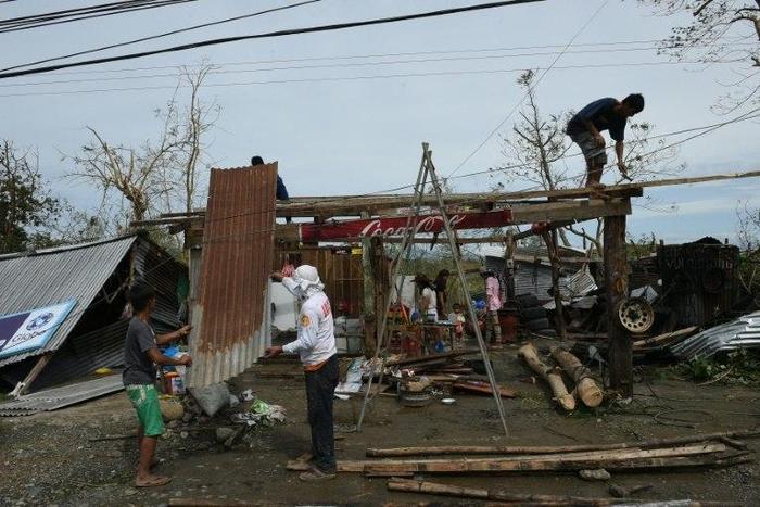 A family fix the roof of their house, damaged at the height of typhoon Haima, in Ilagan town, Isabela province, north of Manila, on October 20, 2016