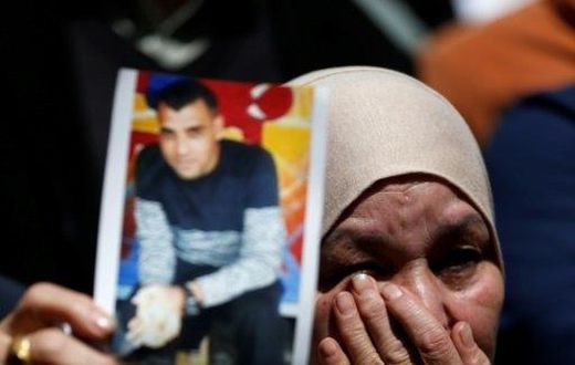 A woman holds the portrait of a Palestinian prisoner during a rally in the West Bank city of Ramallah on April 17, 2017 to show support to hundreds of hunger strikers in Israeli jails