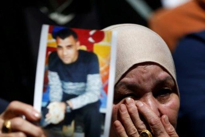 A woman holds the portrait of a Palestinian prisoner during a rally in the West Bank city of Ramallah on April 17, 2017 to show support to hundreds of hunger strikers in Israeli jails