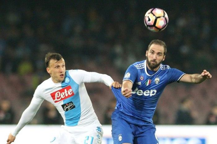 Juventus' forward Gonzalo Higuain (R) fights for the ball with Napoli's defender Vlad Chiriches during the Tim Cup semifinal second leg football match SSC Napoli vs Juventus FC on April 5, 2017