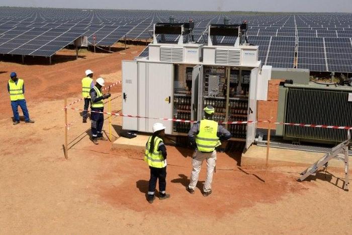 Technicians operate electrical cabinets on October 22, 2016 during the opening ceremony of a new photovoltaic energy production site in Bokhol