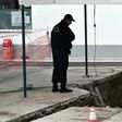 A policeman looks into a hole in Thessaloniki, northern Greece where an unexploded World War II bomb was found during work to expand a petrol station's underground tanks on February 8, 2017