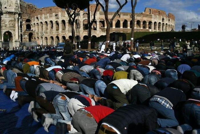 Muslim men attend the Friday prayers during a demonstration near Rome's ancient Colosseum