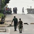 Soldiers patrol near tyres blocking the road in the Plateau business district of the Ivorian capital Abidjan on January 7, 2017 as angry troops took to the streets demanding salary hikes