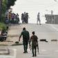 Soldiers patrol near tyres blocking the road in the Plateau business district of the Ivorian capital Abidjan on January 7, 2017 as angry troops took to the streets demanding salary hikes