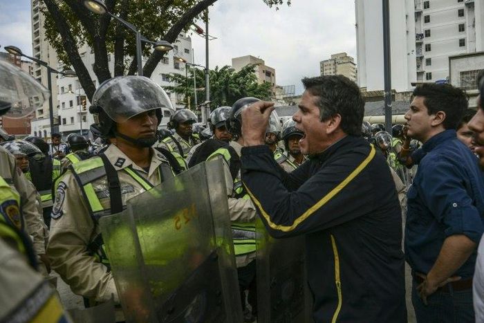 Venezuelan opposition deputy Rafael Guzman (C), confronts National Guard during a protest in front of the National Attorney's General office in Caracas