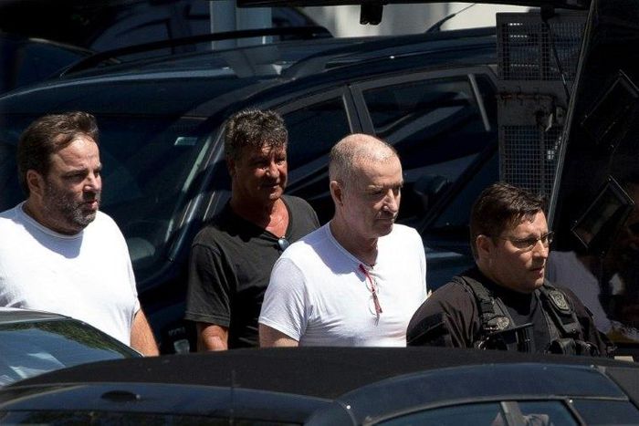 Brazilian businessman Eike Batista (2-R) is escorted as he leaves the Federal Police headquarters after a hearing in Rio de Janeiro, Brazil on February 8, 2017
