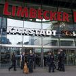 Policemen with a sniffer dog stand in front of the "Limbecker Platz" shopping centre in Essen, western Germany, on March 11, 2017