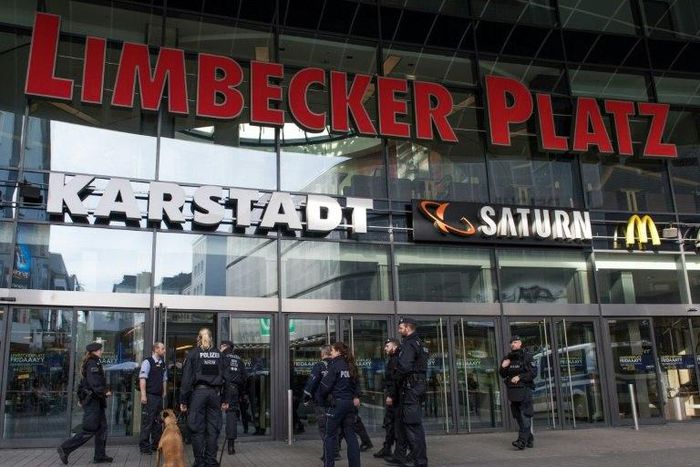 Policemen with a sniffer dog stand in front of the "Limbecker Platz" shopping centre in Essen, western Germany, on March 11, 2017
