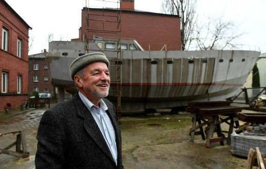 Ship Captain Waldemar Rzeznicki stands in front of a steel schooner named 'Father Boguslaw' under construction, at the courtyard of a homeless shelter run by Catholic Fathers, in Warsaw
