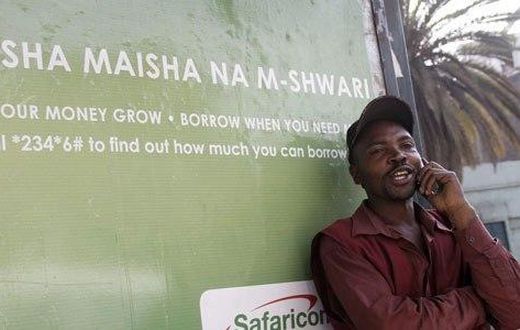 A man on phone next to an M-Shwari branded bus termini in Nairobi. The M-Shwari mobile banking service is set to be launched in Rwanda by April next year before rolling out to West Africa as it spreads its wings across Africa.