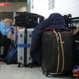 A traveller sleeps next to luggage at London's Heathrow Airport after British Airways cancelled all flights from the major travel hub on May 27, 2017