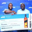 Uki Mariuki a Grand Prix winner from Nairobi receives his dummy air ticket from Joel Kamau, Head of Emerging Beer at KBL. Mr Mariuki is one of the lucky winners travelling to Azerbaijan Grand Prix through Experience Formula 1 with Johnnie Walker promot...