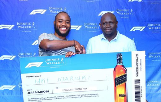 Uki Mariuki a Grand Prix winner from Nairobi receives his dummy air ticket from Joel Kamau, Head of Emerging Beer at KBL. Mr Mariuki is one of the lucky winners travelling to Azerbaijan Grand Prix through Experience Formula 1 with Johnnie Walker promot...