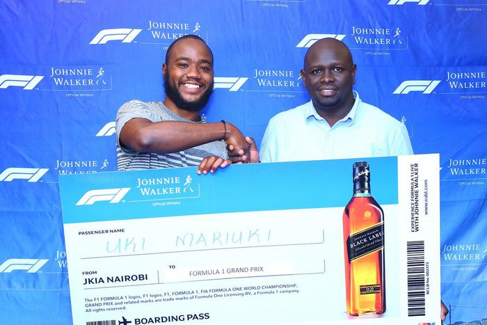Uki Mariuki a Grand Prix winner from Nairobi receives his dummy air ticket from Joel Kamau, Head of Emerging Beer at KBL. Mr Mariuki is one of the lucky winners travelling to Azerbaijan Grand Prix through Experience Formula 1 with Johnnie Walker promot...