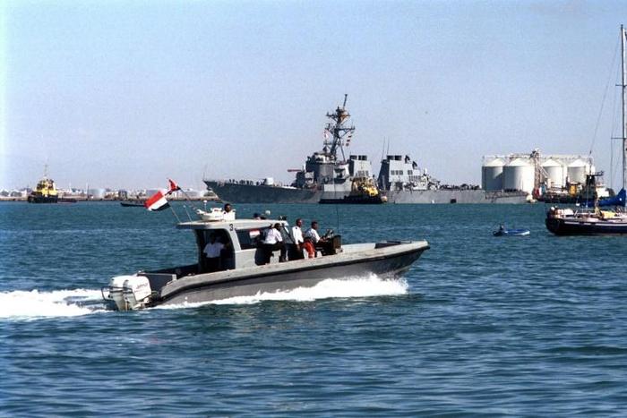 Yemeni marine police patrol around the damaged destroyer USS Cole as it is towed out of Aden harbor on October 29, 2000 -- US President Donald Trump has confirmed that a key plotter of the attack was killed in a US air strike
