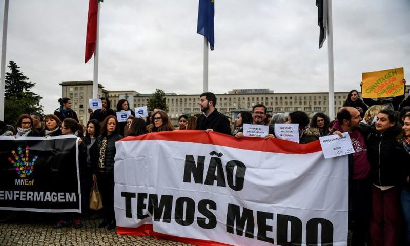 Striking nurses in Portugal, shown here holding a banner reading "We Are Not Afraid", want higher wages, more overtime pay and an end to a freeze on promotions