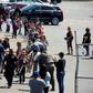 A police officer leads children to be reunited with parents after a gunman entered a classroom and killed one woman and one student, before turning the gun on himself, at North Park Elementary School in San Bernardino, California