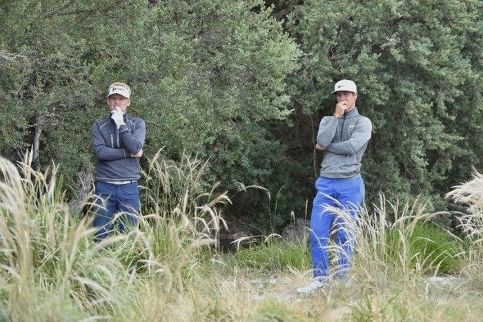 Thorbjorn Olesen (R) and teammate Soren Kjeldsen of Denmark contemplate a way of hitting out of the bushes on the third day of the Golf World Cup in Melbourne on November 26, 2016