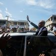 Former Haitian president Jean-Bertrand Aristide greets supporters in Port-au-Prince in a rare public outing to testify in a money laundering case