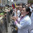 Doctors chant slogans in front of a line of National Guard personnel in riot gear during a demonstration against the shortage in medicines and in rejection of the government of President Nicolas Maduro, in Caracas on May 17, 2017