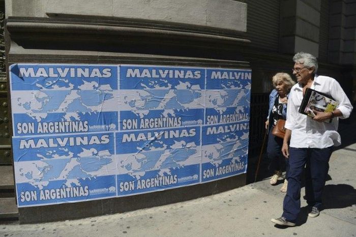 People walk past posters that read 'The Malvinas (Falklands Islands) are Argentine' in downtown Buenos Aires, on March 31, 2016
