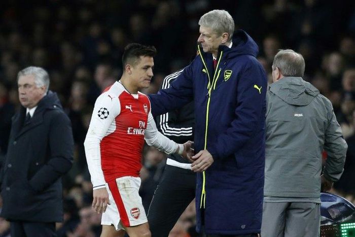 Arsenal manager Arsene Wenger (R) pats Chilean striker Alexis Sanchez on the back as he is substituted during the Champions League last 16 second leg clash with Bayern Munich at The Emirates Stadium in London on March 7, 2017