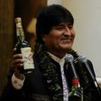 Bolivian President Evo Morales shows a bottle containing a coca-based drink during the ceremony to promulgate a government bill increasing the legal areas of cultivation of coca, at the Quemado presidential palace in La Paz, on March 8, 2017