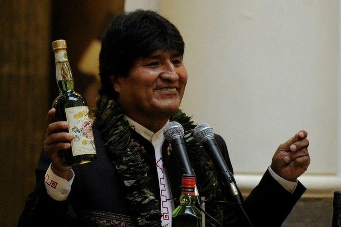 Bolivian President Evo Morales shows a bottle containing a coca-based drink during the ceremony to promulgate a government bill increasing the legal areas of cultivation of coca, at the Quemado presidential palace in La Paz, on March 8, 2017