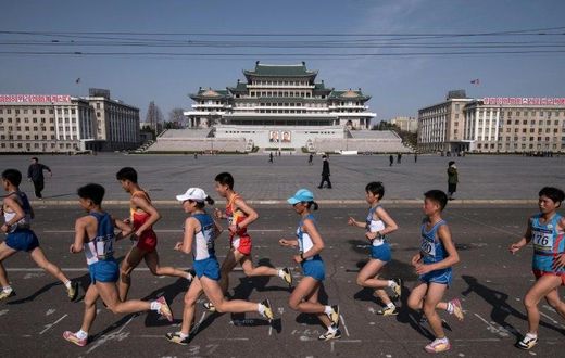Competitors run through Kim Il-Sung square during the Pyongyang Marathon in the North Korean capital