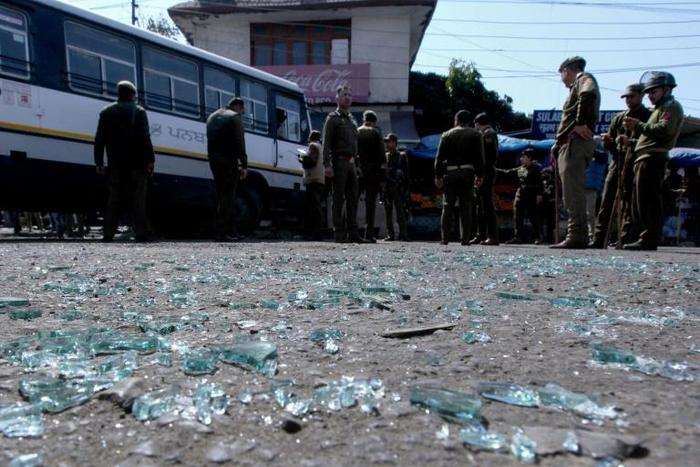 Indian police inspect the site of a grenade blast at a bus station in Jammu