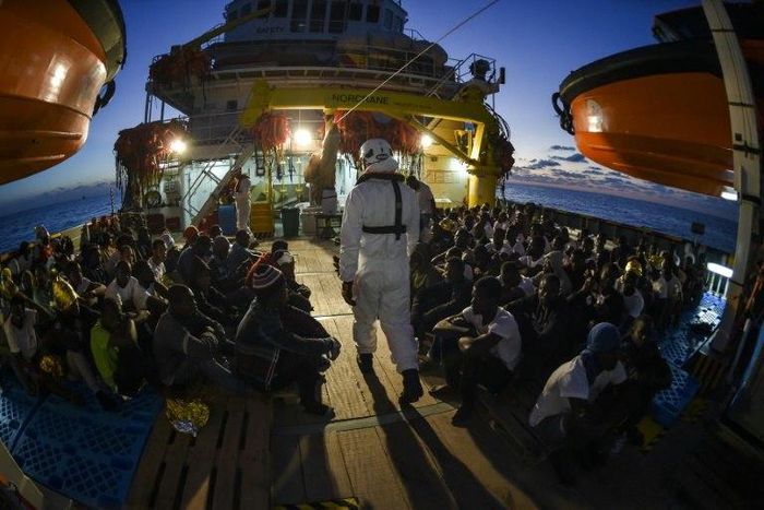 Migrants and refugees wait to be trasferred from the Topaz Responder ship in November 2016
