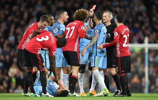 Referee Martin Atkinson (2R) shows the red card to send Manchester United's midfielder Marouane Fellaini (C) off after an altercation with Manchester City's striker Sergio Aguero (3L floor) during the Premier League football match April 27, 2017