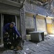Mohammed Nour Mimi looks at a drum as he rummages through his store to find surviving musical instruments in Aleppo's historic souk