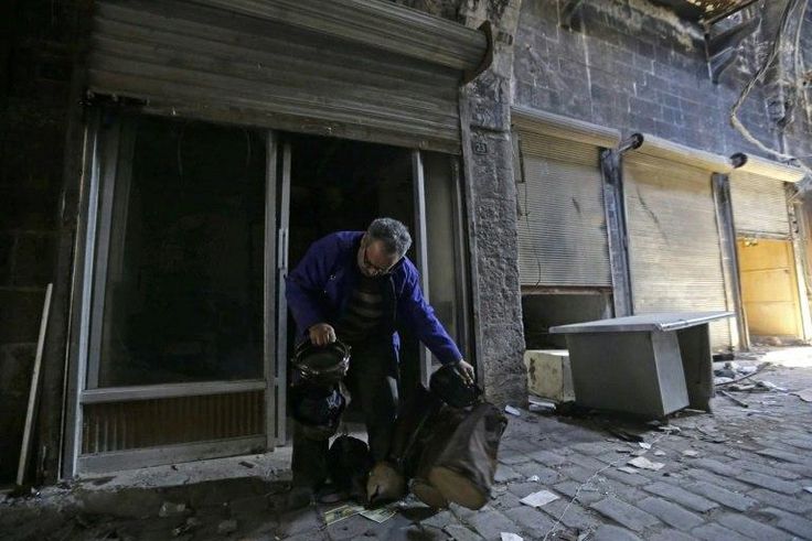 Mohammed Nour Mimi looks at a drum as he rummages through his store to find surviving musical instruments in Aleppo's historic souk