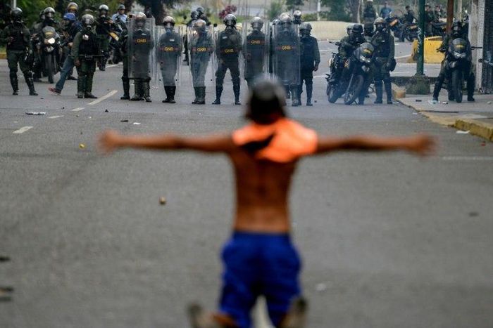 Opposition activists clash with riot police during a protest against President Nicolas Maduro in Caracas on April 26, 2017