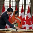 Canadian Prime Minister Justin Trudeau showed Nobel Peace laureate Malala Yousafzai where to sign in a guest book on Parliament Hill before she received an honorary Canadian citizenship