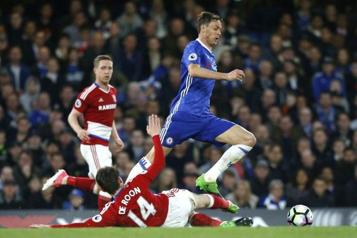 Chelsea's Nemanja Matic (R) skips a tackle by Middlesbrough's Marten de Roon during their English Premier League match, at Stamford Bridge in London, on May 8, 2017