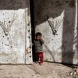 An Iraqi child stands outside a door in west Mosul, northern Iraq, on March 7, 2017, as Iraqi forces battle Islamic State (IS) group fighters to further advance inside the city