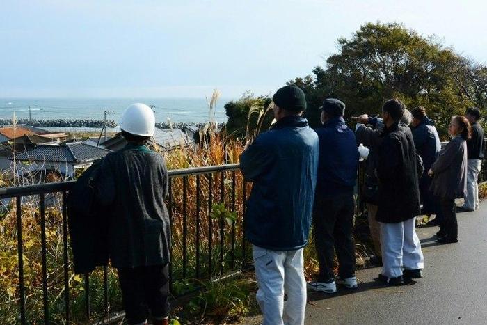 Local residents look out to sea from higher ground after evacuating their homes following a 6.9 magnitude earthquake and tsunami alert in Iwaki, Fukushima prefecture, on November 22, 2016